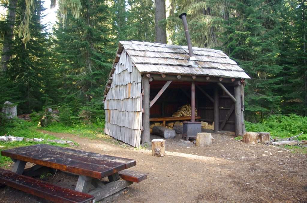 A three-sided wooden shelter and a picnic table.