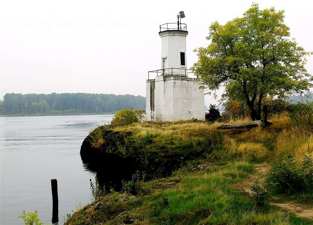 A small lighthouse on a wide river.